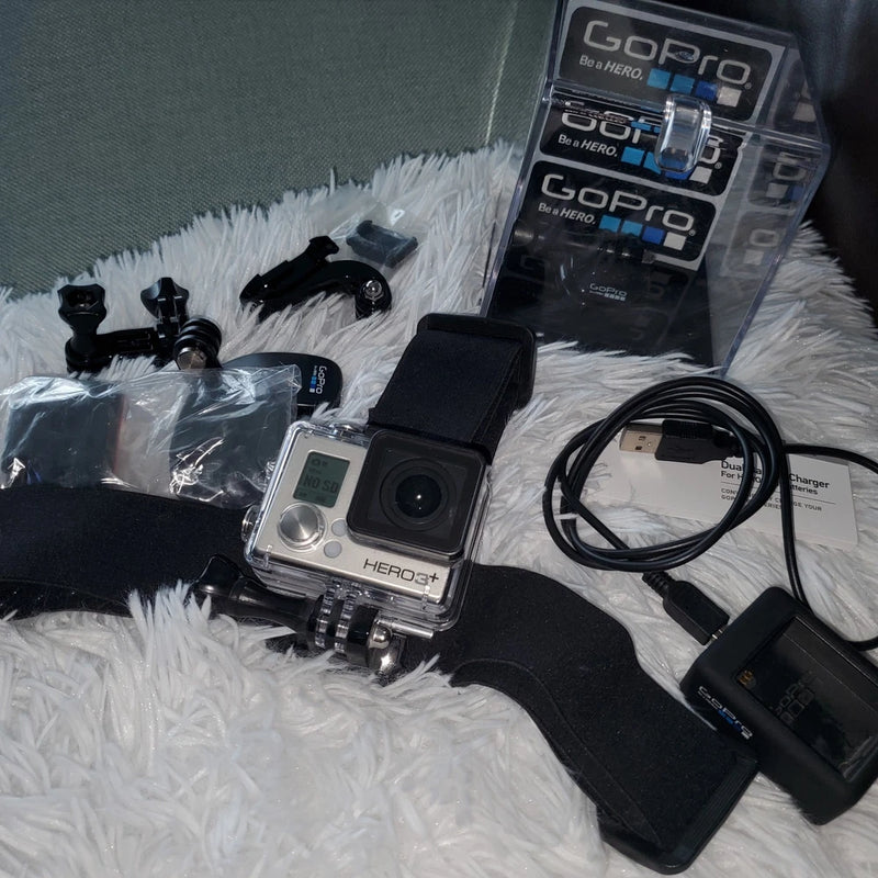 Silver GoPro HERO3+ action camcorder with mounts, head strap, cables, dual charger