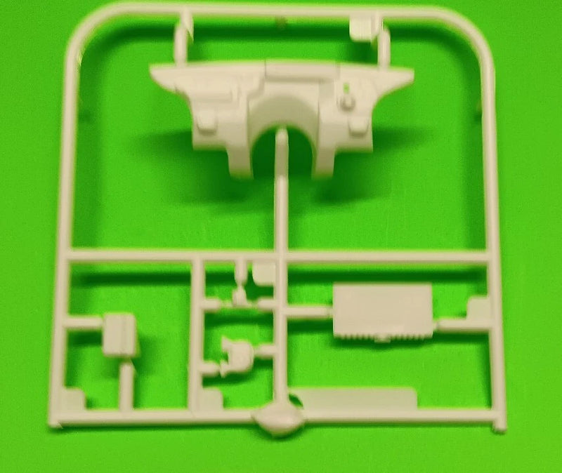 Plastic model car radiator and battery parts sprue on frame, white molded pieces