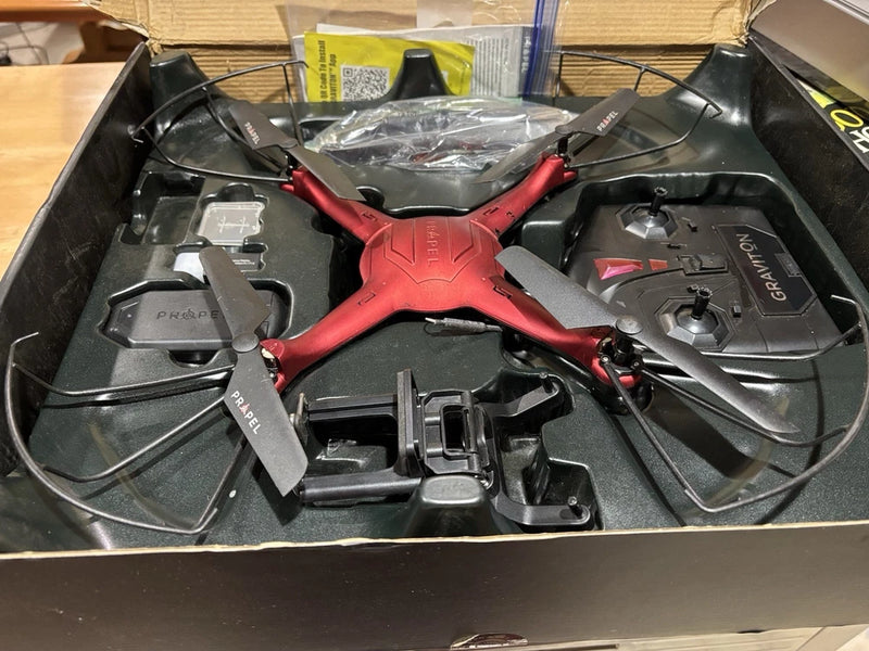 Red and black quadcopter drone with four propellers and central control pod
