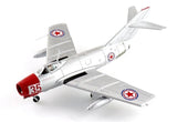 White fighter jet model with red nose and star insignia, landing gear extended