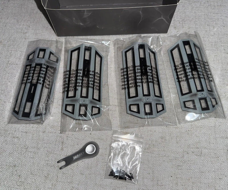 Drone replacement accessory kit: grey plastic frames, small tool, and screws