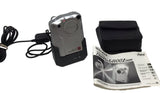 Silver digital camera with manual and charger, shown with cables and booklet.