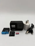 Black action camera bundle with SD card, charger plug, and case