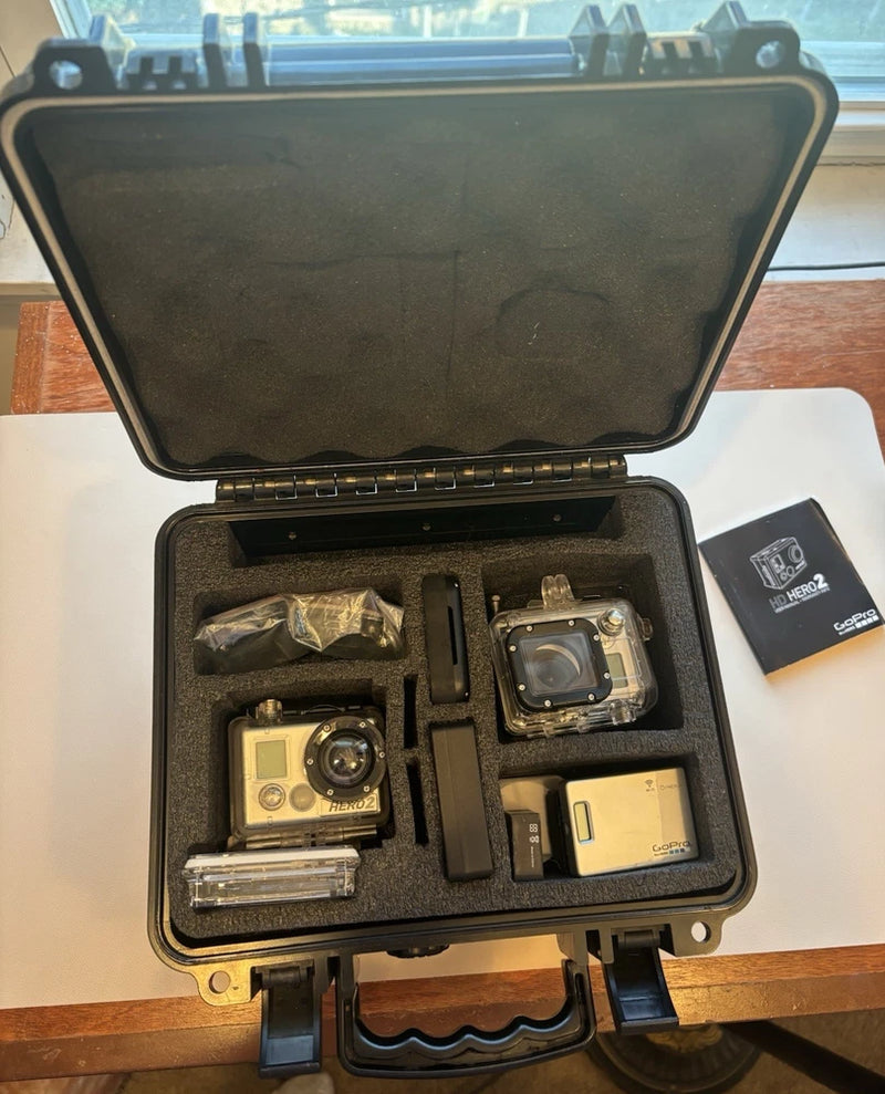 GoPro HERO2 HD action camera kit open case with cameras, mounts, and MicroSD card