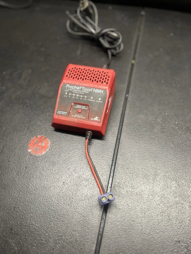 NiMH battery charger with red housing and attached black power cable and plug