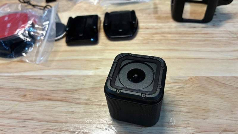 Black action camera with square lens module and front status control on top