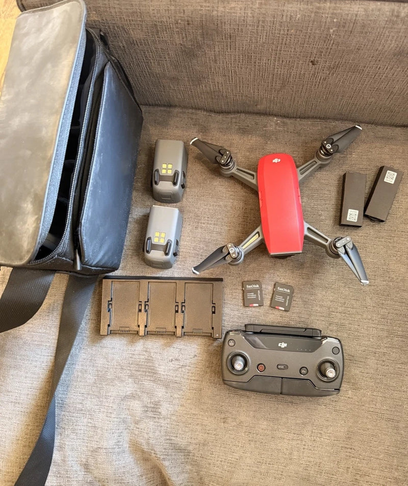 Red DJI Spark drone kit with controller, batteries, charger, propellers and case
