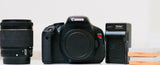 Black Canon EOS Rebel DSLR camera with 18-55mm lens and spare batteries