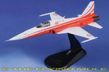 Red and white F-5E Tiger II jet model with display stand