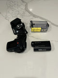 Black Sony action camera with mounting bracket, battery pack, and charging module