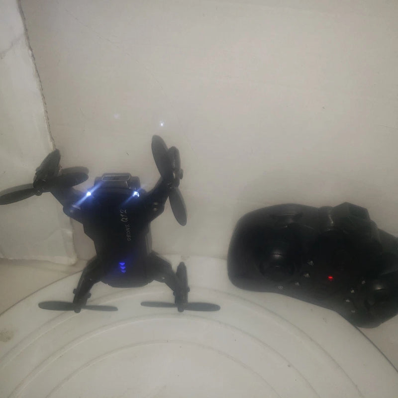 Foldable mini camera drone with four propellers and LED lights