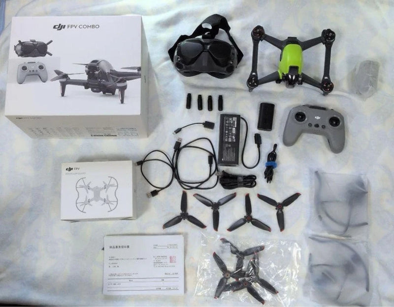 FPV drone kit set with green quadcopter, FPV goggles, remote controller, spare parts