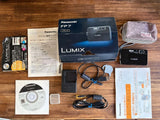 Black Panasonic LUMIX DMC-FP7 compact digital camera with accessories and manuals