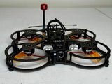 Black quadcopter drone with front camera, four propellers, red status light