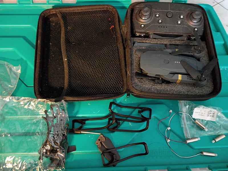 Collapsible RC quadcopter drone in open hard case, folded arms and controller parts