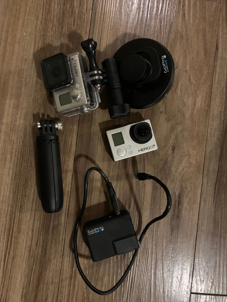 GoPro action camera kit with silver camera, black mounts, housing, and connecting cable