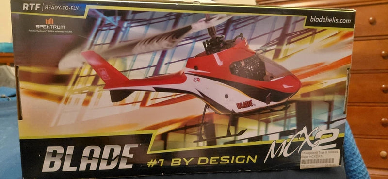 Red, white, and black RC helicopter box showing Blade MCX2 model