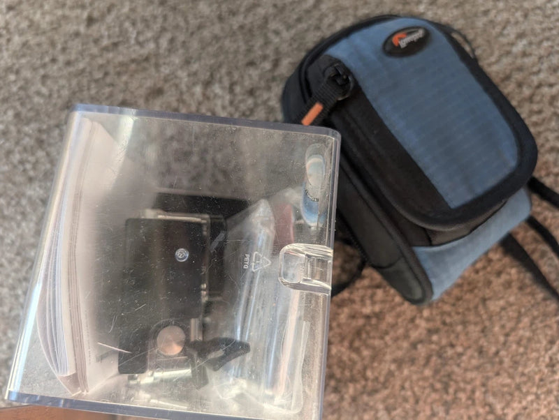 Silver action camera in clear protective case with black storage pouch