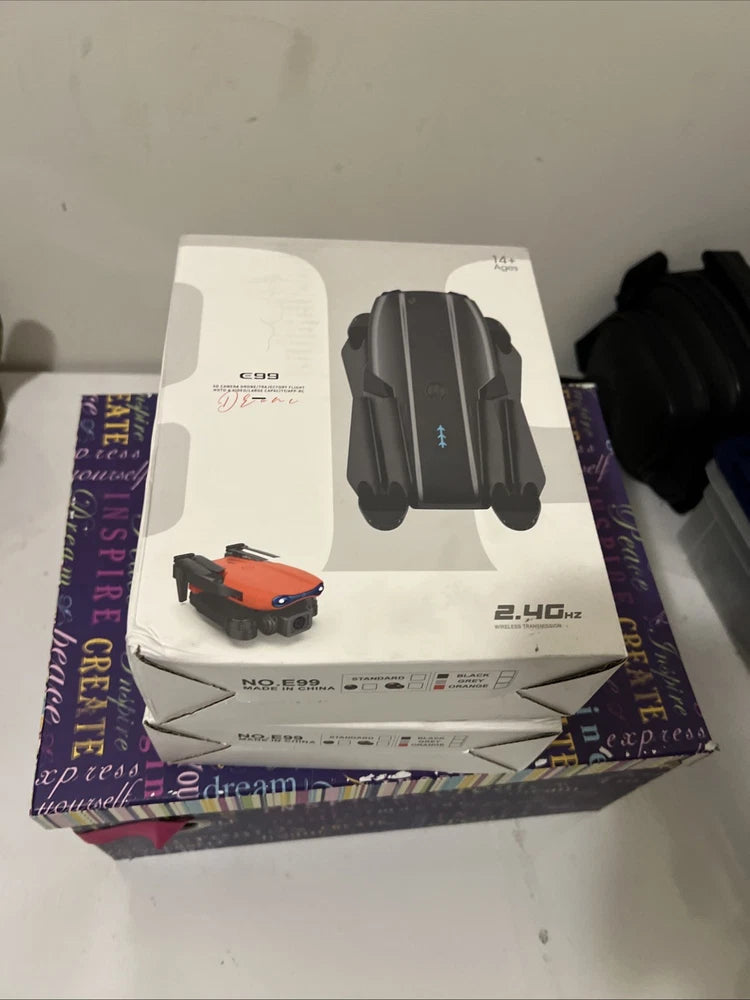 Gray foldable quadcopter drone with camera and LED lights, retail box