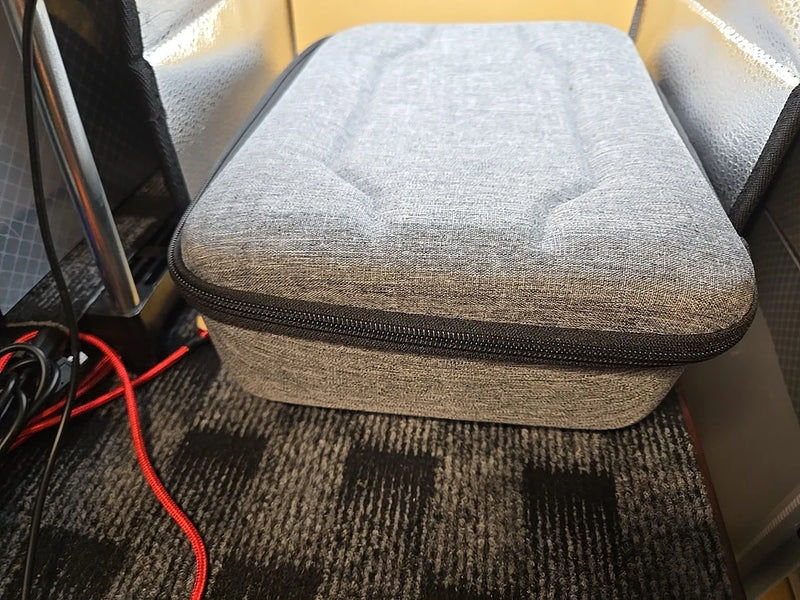 Gray zippered carrying case with textured fabric and hard shell