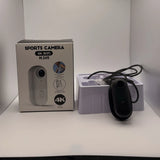 Black helmet action camera with wrist strap and protective case, in retail box.