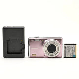 Pink FUJIFILM compact digital camera with lens and battery pack, shown open back.