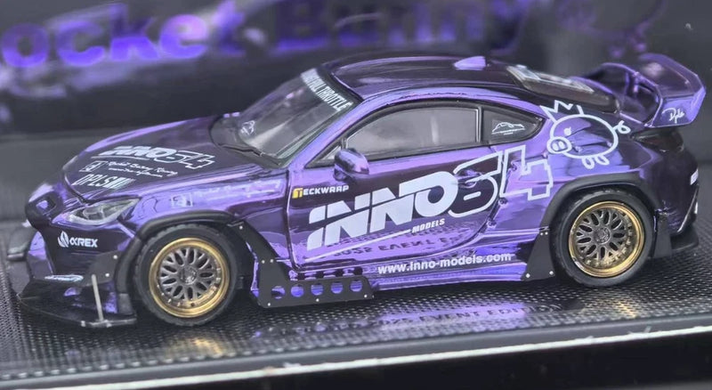 Purple and black INNO64 GR86 model car with gold wheels, side decals