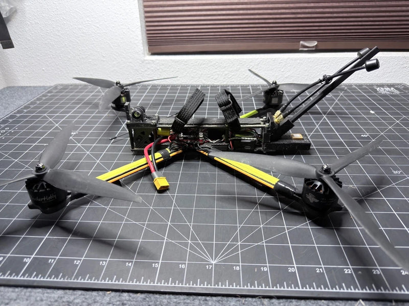 Long-range FPV quadcopter drone, black frame with yellow arms and antennas