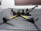 Long-range FPV quadcopter drone, black frame with yellow arms and antennas