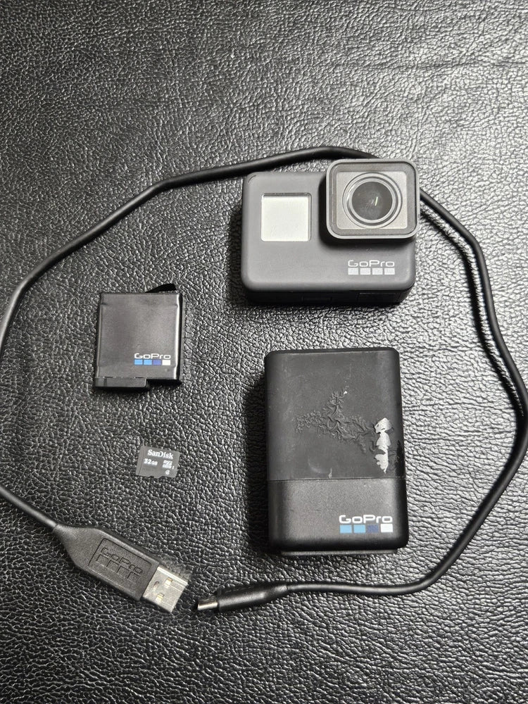 GoPro Hero 5 action camera with lens, battery, microSD card, and USB cable