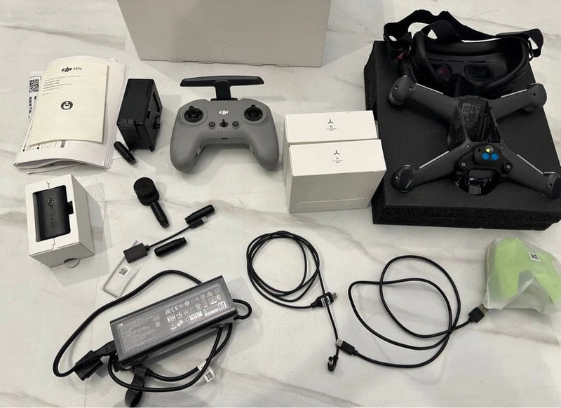 FPV drone kit with quadcopter, controller, goggles, cables, and power adapters