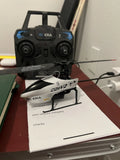RC helicopter toy with black remote controller and compact rotor frame
