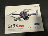 GPS mini drone on box, gray quadcopter with four propellers and front camera