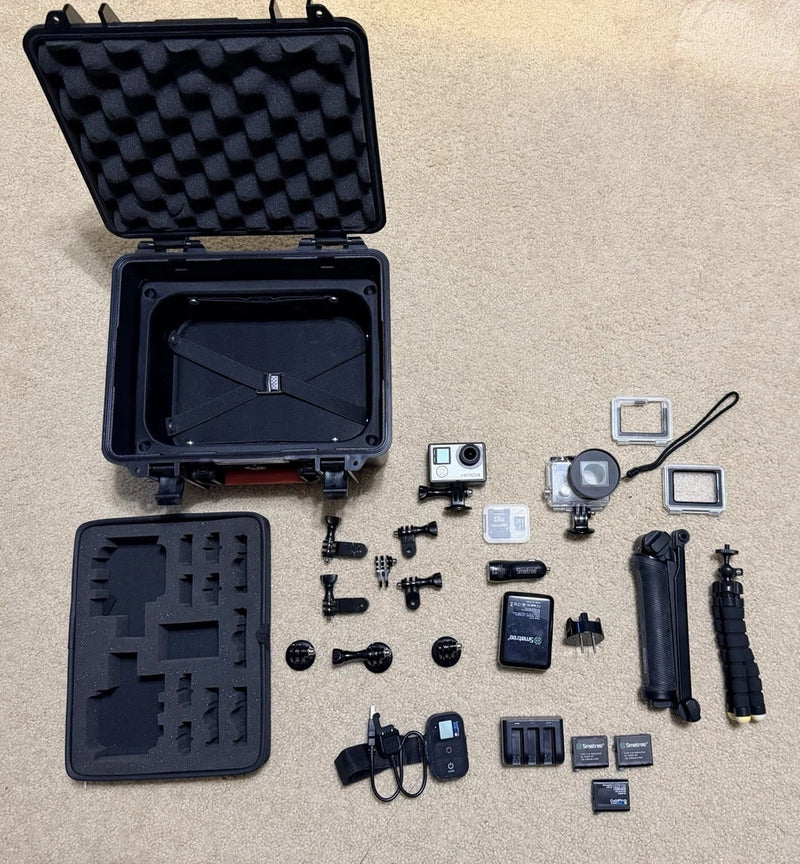 GoPro HERO4 action camera kit in open hard case with mounts, battery, and accessories