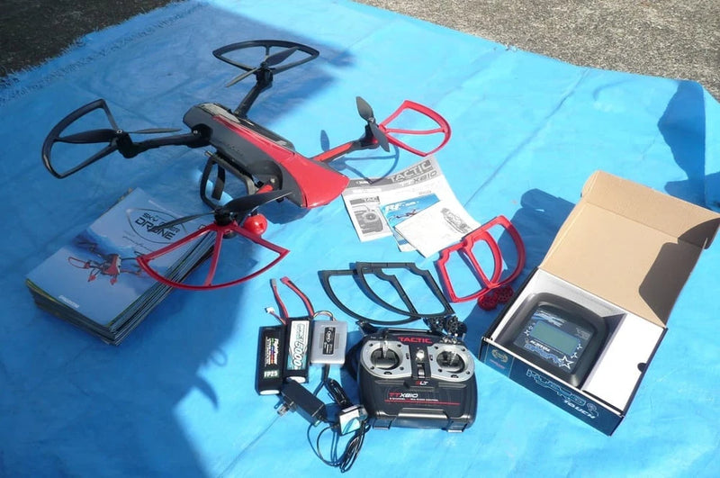 Red and black quadcopter drone with camera, remote controller with screen and manuals