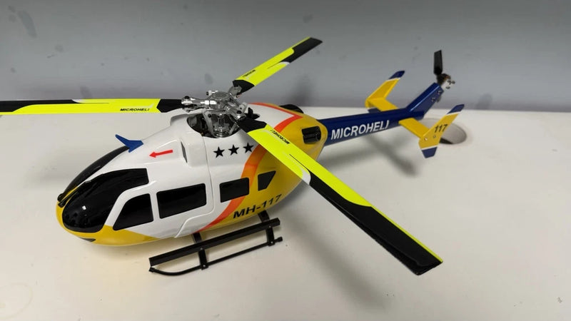 RC helicopter model with yellow and white fuselage, main rotor blades and tail rotor