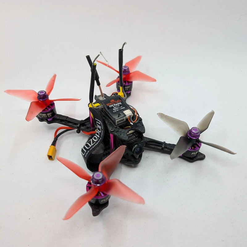 Micro FPV racing quadcopter drone with black frame and orange four propellers