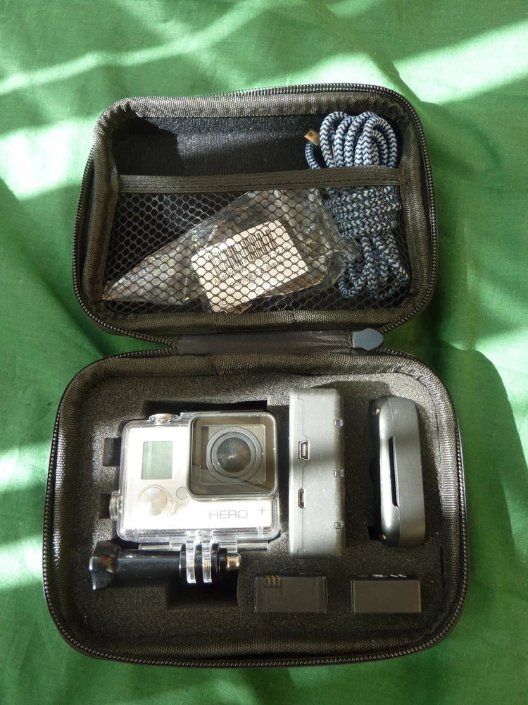 Open black carrying case with silver GoPro action camera and mounts