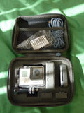 Open black carrying case with silver GoPro action camera and mounts