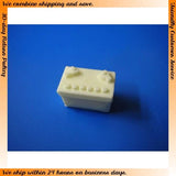 Small light-colored rectangular battery pack with multiple contacts