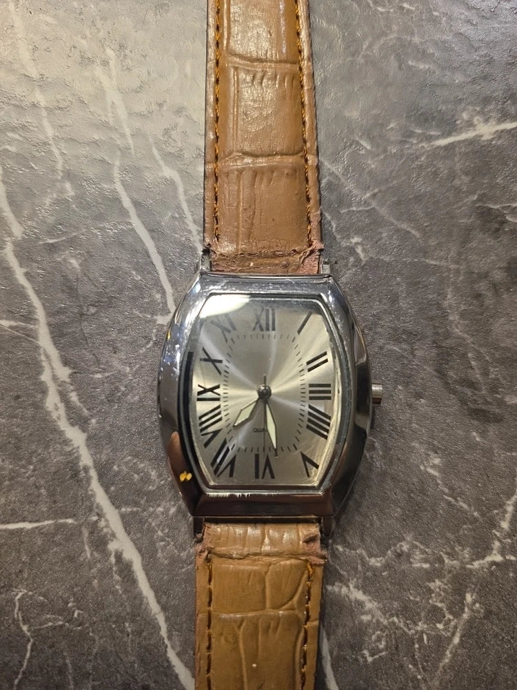 Silver dial quartz wristwatch with roman numerals, brown leather strap