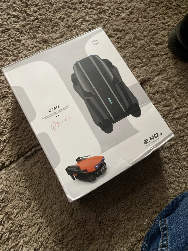 Foldable quadcopter FPV drone in retail box, showing black camera drone