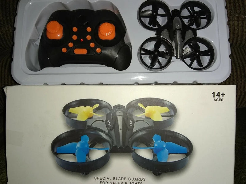 Mini RC drone toy kit with orange-black controller and four propeller blades