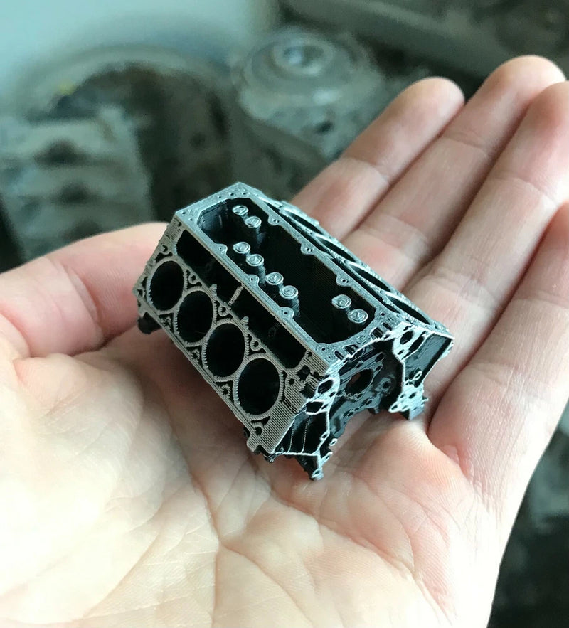 Miniature LS engine block replica with cylinder bores and bolt holes, metallic gray