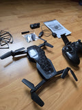 Compact foldable drone with four propellers and handheld remote controller