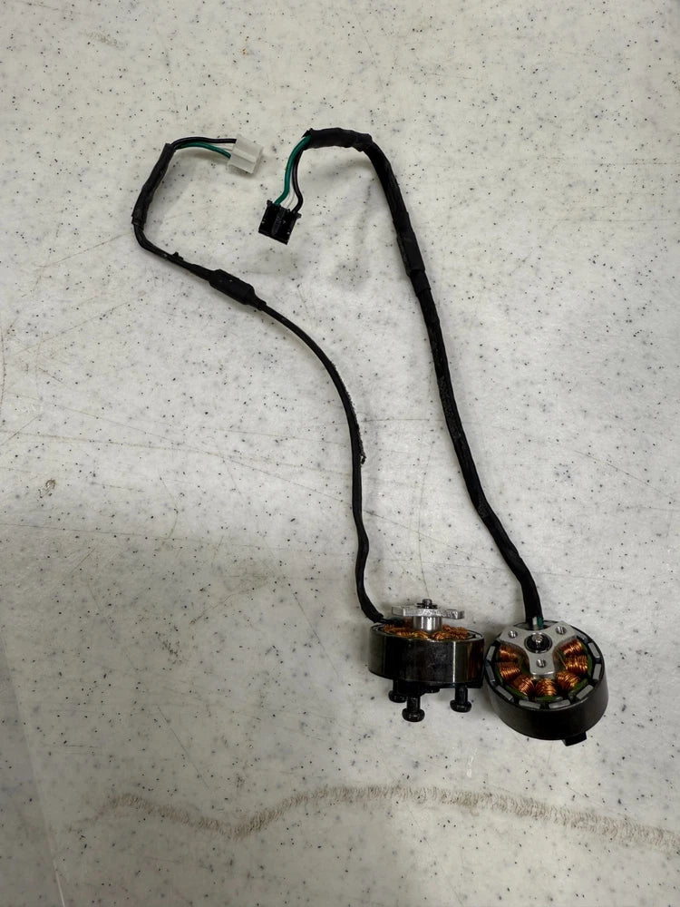Pair of small brushless DC drone motors with attached wiring leads and connectors