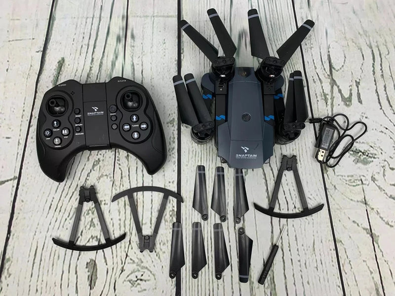 SNAPTAIN foldable quadcopter drone with camera, remote controller, and cables