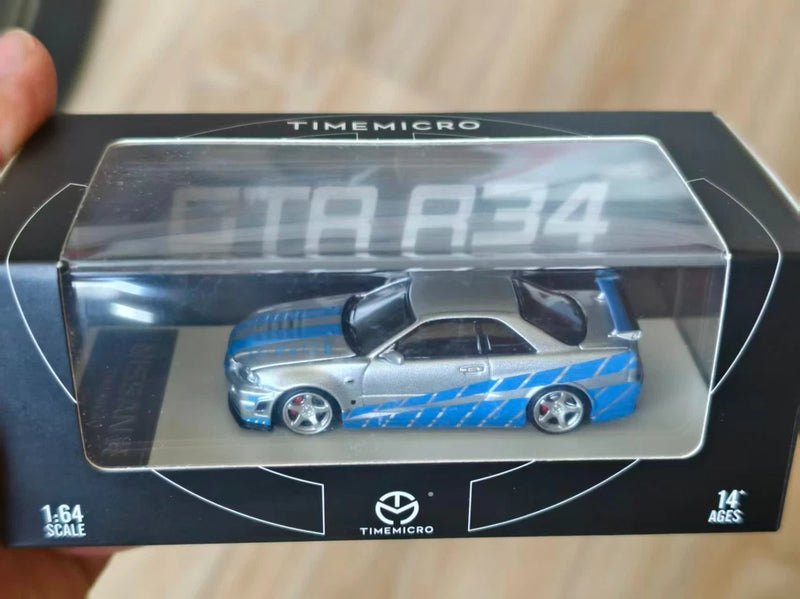 1:64 scale Nissan GTR R34 die-cast car model in blue and silver packaging