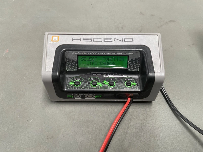 Ascend lipo balance charger with LCD screen and green buttons, red and black leads