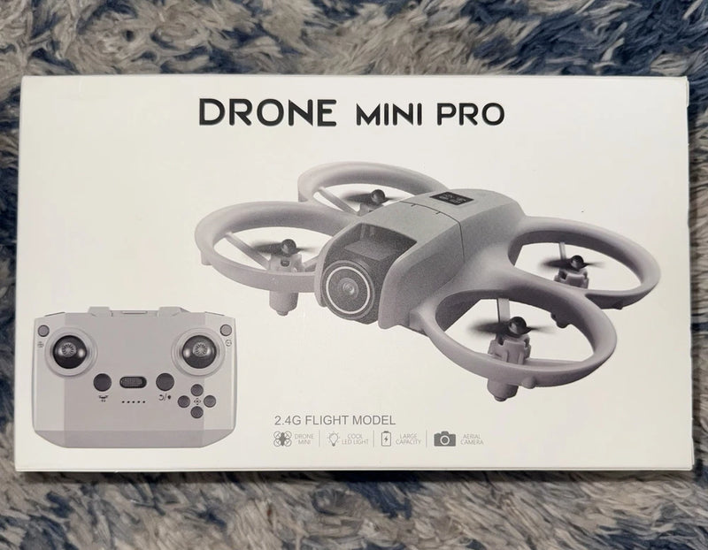 Gray RC mini quadcopter drone with camera and controller on retail box